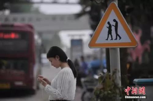 資料圖：重慶一紅綠燈處擺放“不做低頭族、關注紅綠燈”警示牌。 陳超 攝