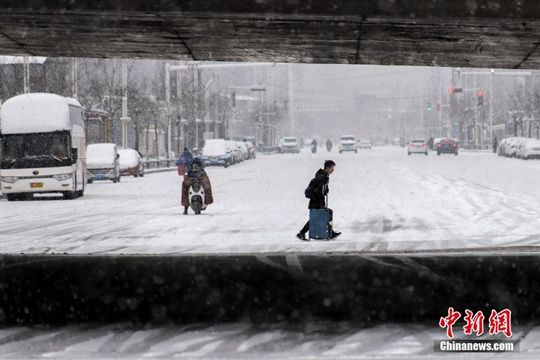 河南迎降雪天氣 民眾冒雪拎行李箱出行